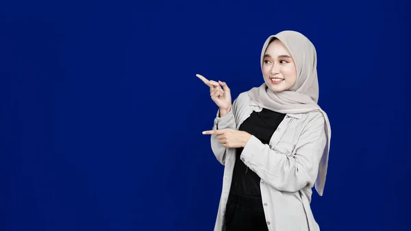 Asiatico Hijab Donna Indicando Sinistra Spazio Vuoto Isolato Blu Sfondo — Foto Stock