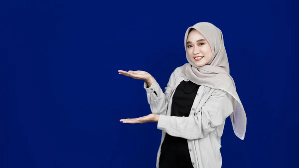 Asiatische Hijab Frau Zeigt Links Leerraum Isoliert Blauen Hintergrund — Stockfoto