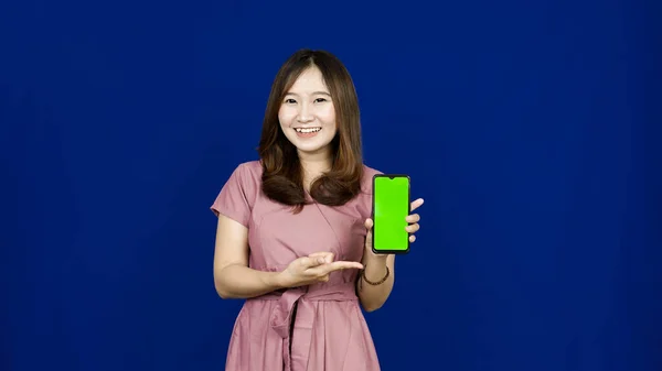 Hermosa Mujer Asiática Apuntando Pantalla Verde Teléfono Aislado Fondo Azul —  Fotos de Stock