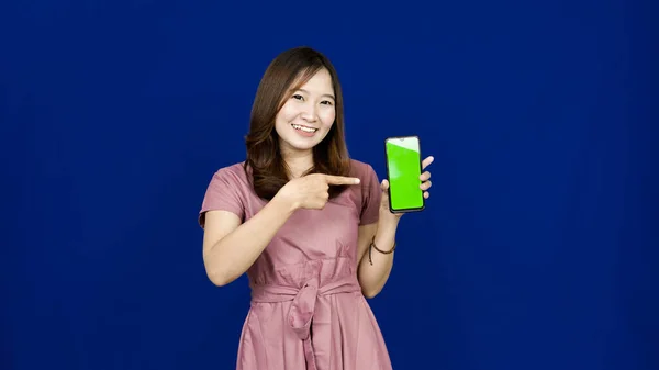 전화로 화면을 가리키고 아름다운 아시아인 여자푸른 — 스톡 사진