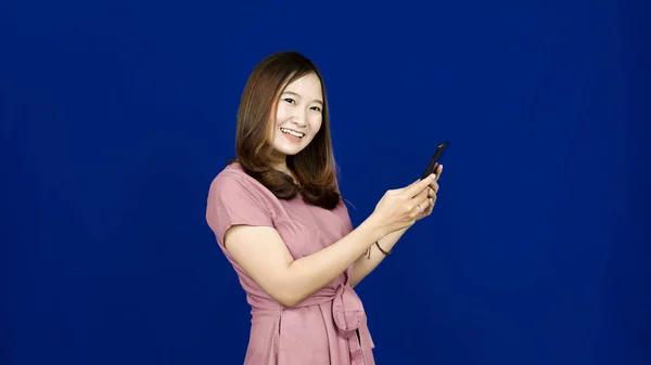 Schöne Asiatische Frau Lächeln Sehen Handphone Isoliert Blauen Hintergrund — Stockfoto