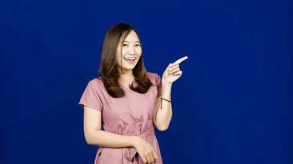 Asiático Mujer Apuntando Derecho Espacio Blanco Aislado Azul Fondo —  Fotos de Stock
