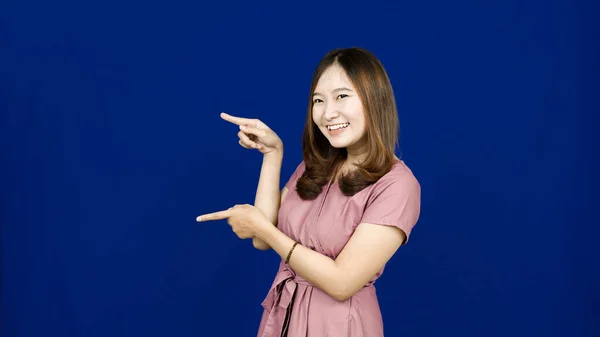 Asiático Mujer Apuntando Izquierda Espacio Blanco Aislado Azul Fondo —  Fotos de Stock