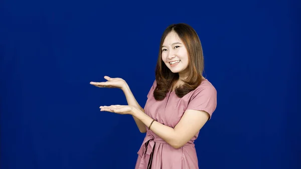 Asiático Mulher Apontando Esquerda Espaço Branco Isolado Azul Fundo — Fotografia de Stock