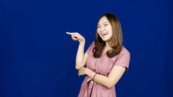 Asiático Mujer Apuntando Izquierda Espacio Blanco Aislado Azul Fondo —  Fotos de Stock