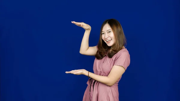 Asiático Mujer Apuntando Izquierda Espacio Blanco Aislado Azul Fondo —  Fotos de Stock