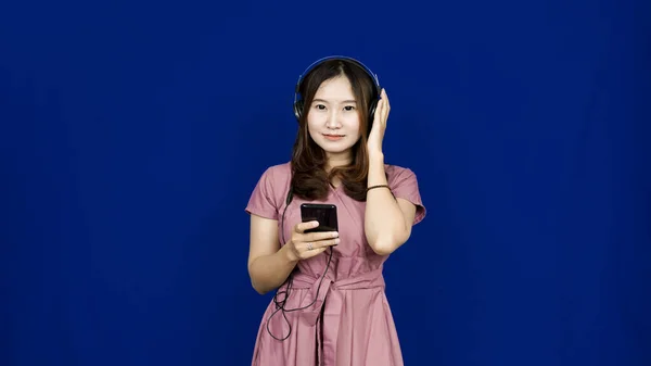 Ázsiai Hallgatni Dalok Segítségével Fejhallgató Elszigetelt Kék Backg — Stock Fotó