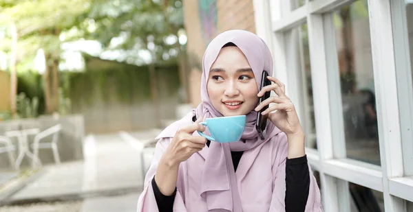 Feliz Asia Hijab Mujer Usando Teléfono Inteligente Llamando Beber Café —  Fotos de Stock