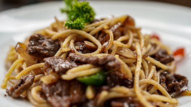 Masanın üstünde beyaz tabaklı spagetti.