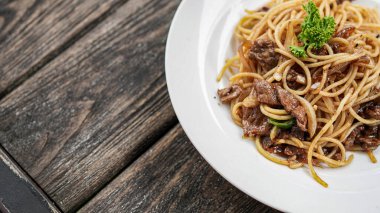 Masanın üstünde beyaz tabaklı spagetti.