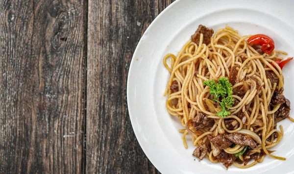 Masanın üstünde beyaz tabaklı spagetti.