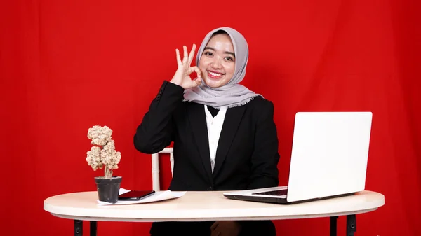 business Asian woman wearing hijab ok gesture isolated blue background