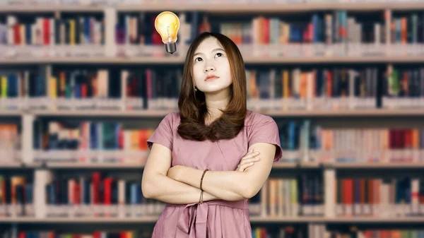 beautiful asian woman thinking and get idea with library background