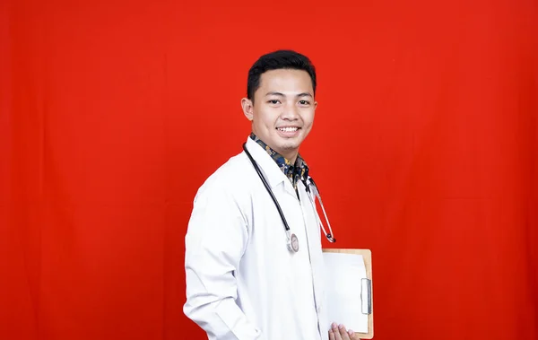 Asian Male Doctor Holding Clipboard Isolated Red Background — Stock Photo, Image