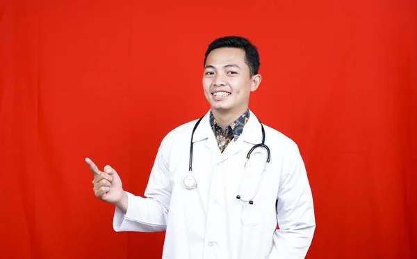 Asyalı Erkek Doktor Boş Alanı Işaret Ederek Izole Edilmiş Kırmızı — Stok fotoğraf