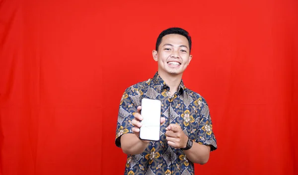 Asiatisk Man Med Batik Kläder Och Pekar Grön Skärm Mobiltelefon — Stockfoto