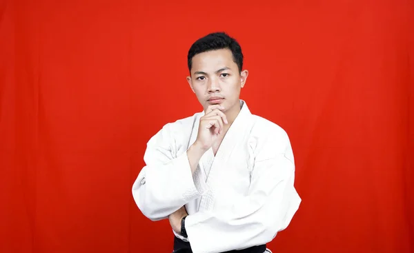Asiatische Karate Mann Denken Und Bekommen Idee Isoliert Roten Hintergrund — Stockfoto