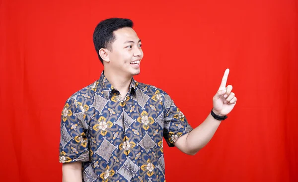 Asian Man Wearing Batik Pointing Blank Space Isolated Red Background — Stock Photo, Image