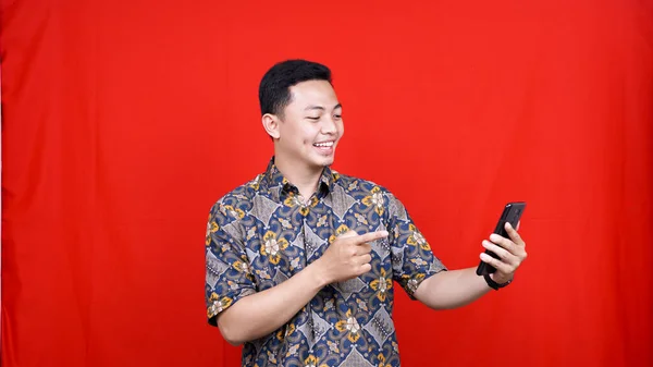 Asijský Muž Vzrušený Výraz Pohled Mobilní Telefon Batik Oblečení — Stock fotografie