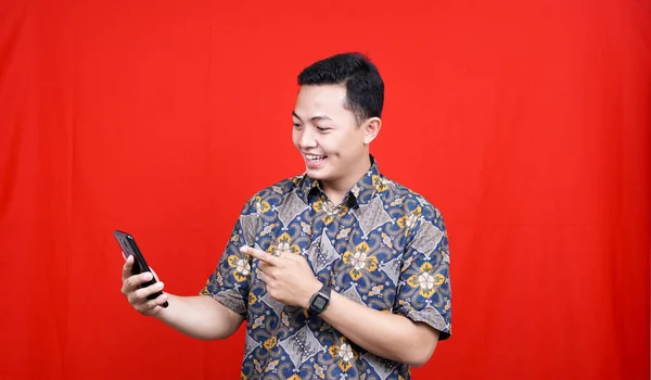 Азиатский Человек Взволнован Выражение Смотреть Сотовый Телефон Батик Одежды — стоковое фото