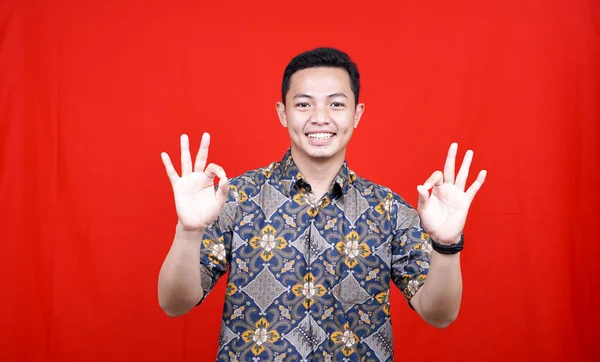 Asiatische Mann Ausdruck Mit Batikkleidung Studio Isoliert Mit Rotem Hintergrund — Stockfoto