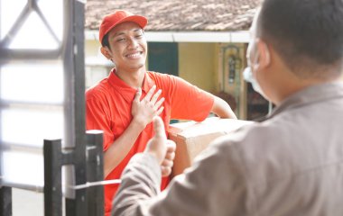 Teslimatçı, kutuyu müşteriye teslim eder.