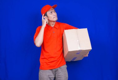 Teslimatçı düşünüyor ve mavi arka plan hakkında fikir ediniyor.