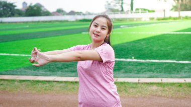 Koşmadan önce Asyalı kadın ısınıyor.