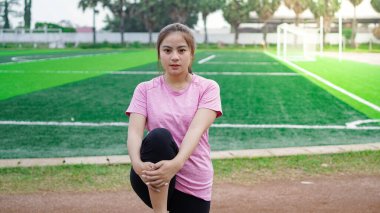 Koşmadan önce Asyalı kadın ısınıyor.