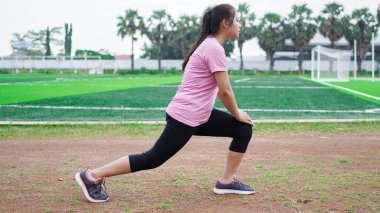 Koşmadan önce Asyalı kadın ısınıyor.