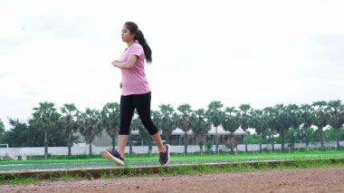 Koşu yolunda koşan Asyalı kadın sporcu