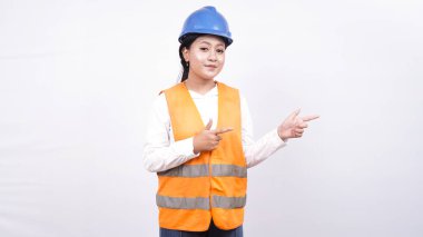 Asyalı mühendisin portresi beyaz arkaplanda izole edilmiş ve boş alanı işaret ediyor