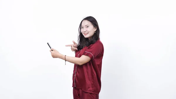 Retrato Una Joven Mujer Asiática Con Pijama Apuntando Teléfono Aislado —  Fotos de Stock