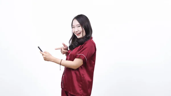 Retrato Una Joven Mujer Asiática Con Pijama Apuntando Teléfono Aislado —  Fotos de Stock