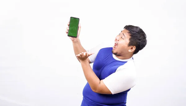緑色の画面の電話を持つ面白いアジア人男性隔離された白い背景 — ストック写真