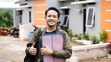 Yeni evlerinin önünde duran genç adamların portresi.