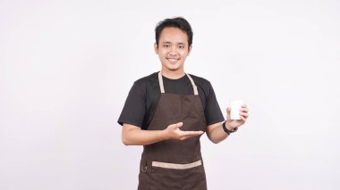 Önlük giyen adam beyaz arka planda durup camı işaret ediyor.