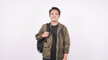 Çanta takan genç bir öğrenci, beyaz arka planda izole edilmiş.