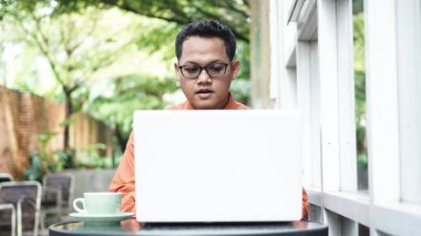 Genç Asyalı girişimciler dizüstü bilgisayara bakıyor