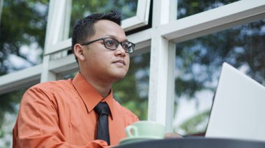 Genç Asyalı girişimciler dizüstü bilgisayara bakıyor