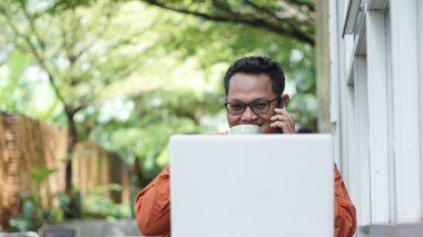 Girişimciler bilgisayarlarda çalışıyor telefonla kahve içiyorlar