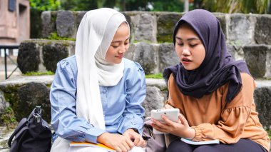 İki Asyalı kız öğrenci arkadaş tartışıyorlar 