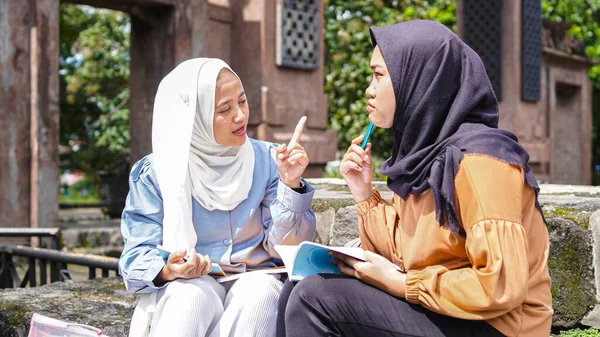 İki Asyalı kız öğrenci arkadaş tartışıyorlar 