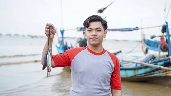 Happy Young Fisherman Beach Holding His Catch Fish Shows Front — Stock Photo, Image