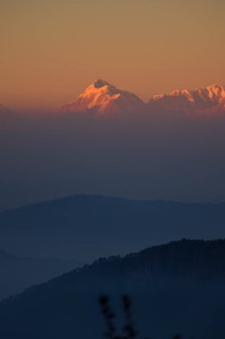 Güneşin son ışıkları altın tepelere vururken, trishul zirvesinin güzel manzarasının tadını çıkarıyorlar.