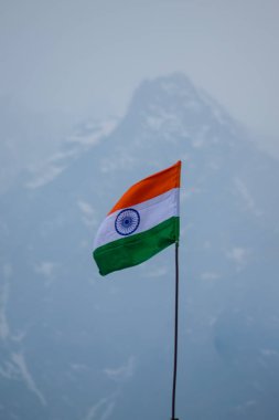 Himalaya dağlarında rüzgarın basıncıyla dalgalanan üç renkli Hint bayrağı