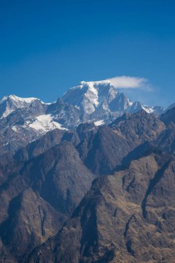 Çok güneşli bir günde Uttarakhand bölgesinin Himalaya tepeleri karla kaplıydı.