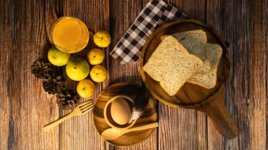 Sabah kahvaltısı, portakal suyu, ahşap tabakta tam buğday ekmeği ve yumurta, üst manzara..