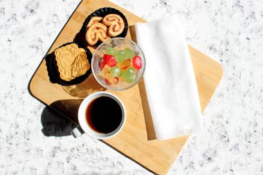 Kurabiye ve şekerli bir fincan çay. Metin eklenecek yer. Kahvaltı veya atıştırmalık konsepti. Ahşap arkaplan, siyah arkaplan, ışık arkaplan.