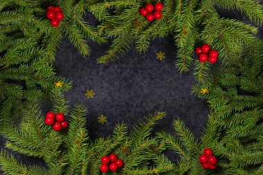 Noel tatili arkaplanı ve metin için fotokopi alanı. Düz yerde, üst tarafta. Köknar dalları ve kutsal meyvelerin dekoratif çerçevesi